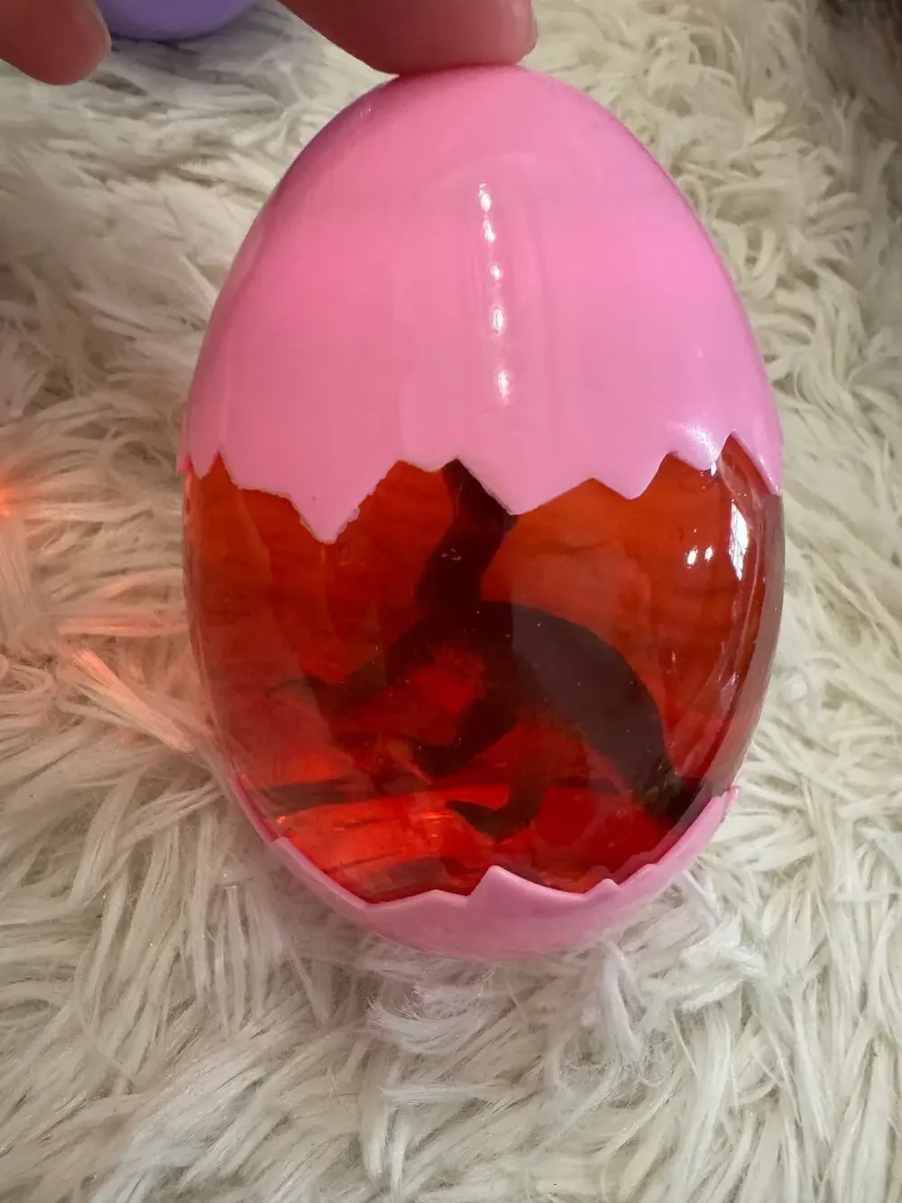 Pink slime in a dinosaur egg with a plastic assorted dinosaur insid
